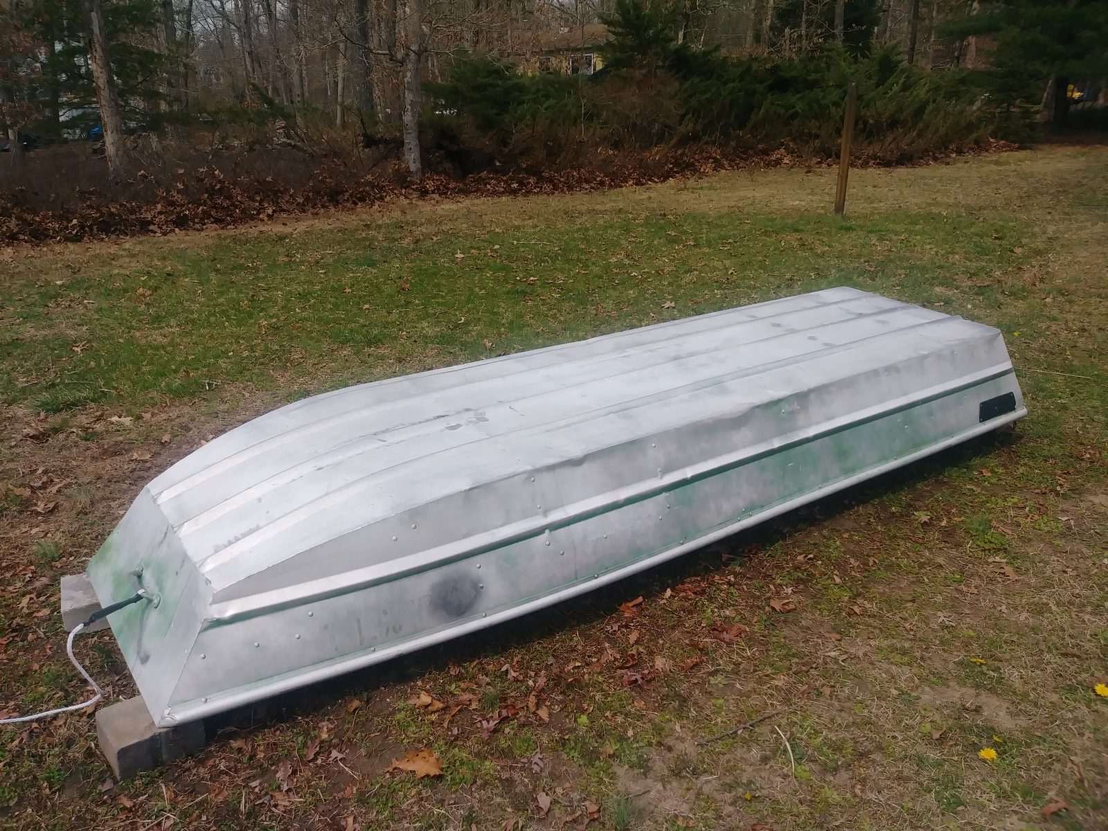 Bare hull set up on blocks in the yard, ready to be flipped for painting
